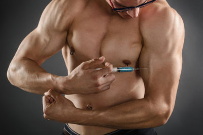 42262046 - close up of a muscular man injecting himself with steroids